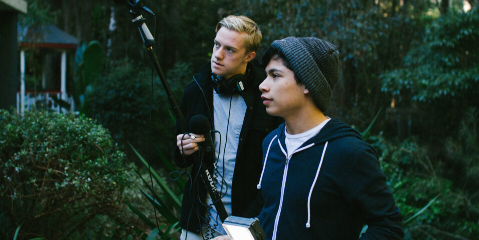 Two students filming and recording sound on outdoor set
